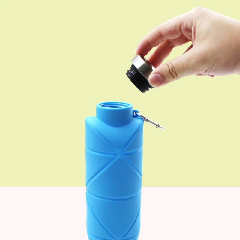 Collapsible silicone water bottle folded flat next to an expanded bottle for travel